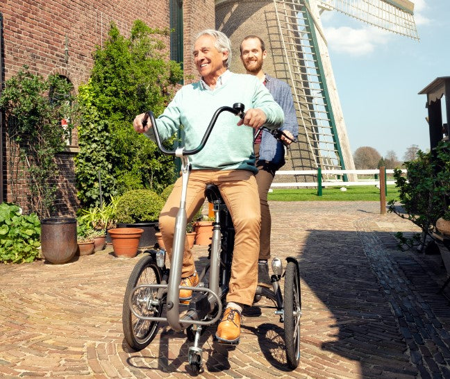 support person riding electric bike with elderly