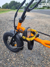Close up view of pedals on orange coloured Trident FT fat-tyre semi-recumbent electric tricycle