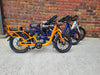 Line up of orange, navy and white electric bike