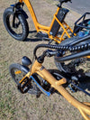 Gold tricycle next to orange tricycle