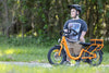 rider looking away while next to the orange lightning electric bike