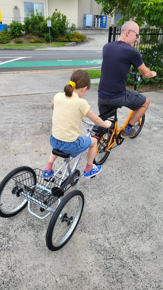 Young girl riding behind man on a Tandem Trailer Trike 