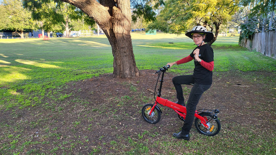 Lady riding the red BF i-Ezi Folding Electric Bike at the park