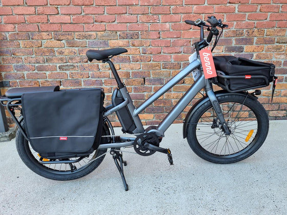 Silver Benno Boost electric long-tail cargo bike against brick wall
