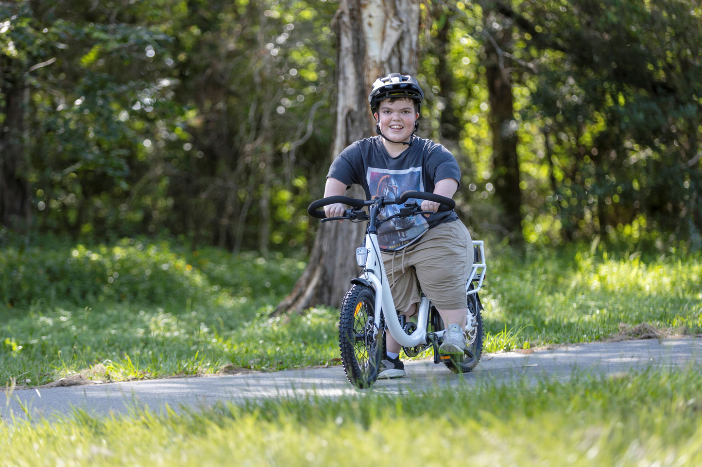 young man with acondroplasia riding a white lightning electric bike