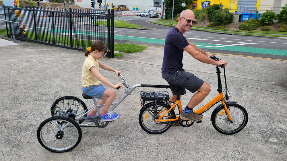 child and father riding a electric bike