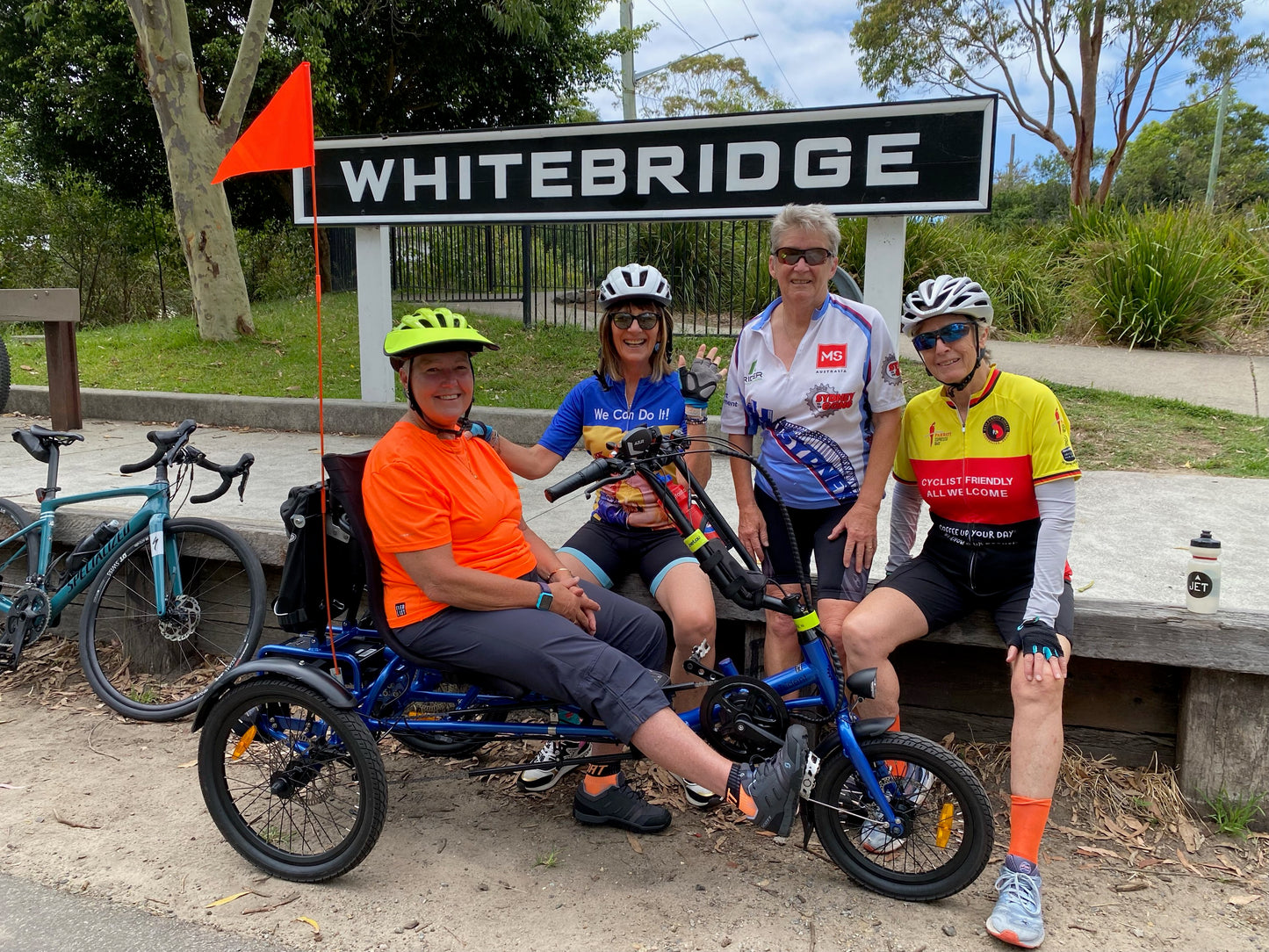 Women helping disabled man go for a bike ride