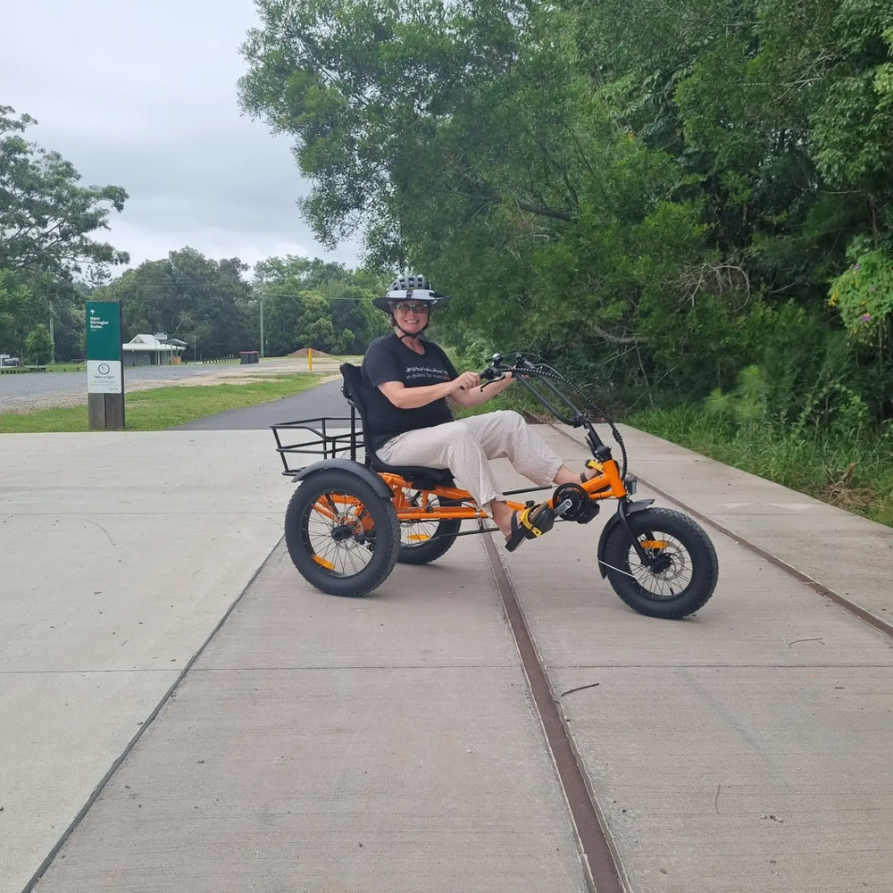 
                      
                        Smiling lady on orange Trident FT fat-tyre semi-recumbent electric tricycle
                      
                    