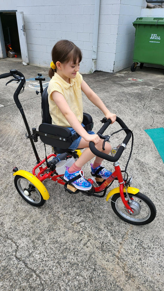 Young gilr riding the Muskateer 14" tricycle with rear steer and special needs mods