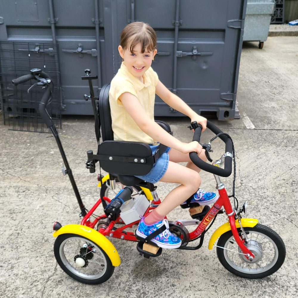 
                      
                        Smiling child while riding the Muskateer 14" tricycle with rear steer and special needs mods
                      
                    