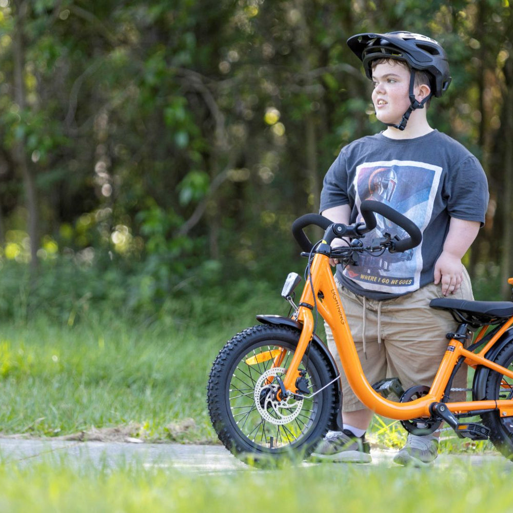 
                      
                        rider looking away while next to the orange lightning electric bike
                      
                    