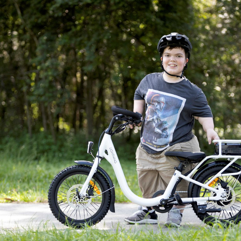 
                      
                        Short Stature rider next to white lightning electric bike
                      
                    