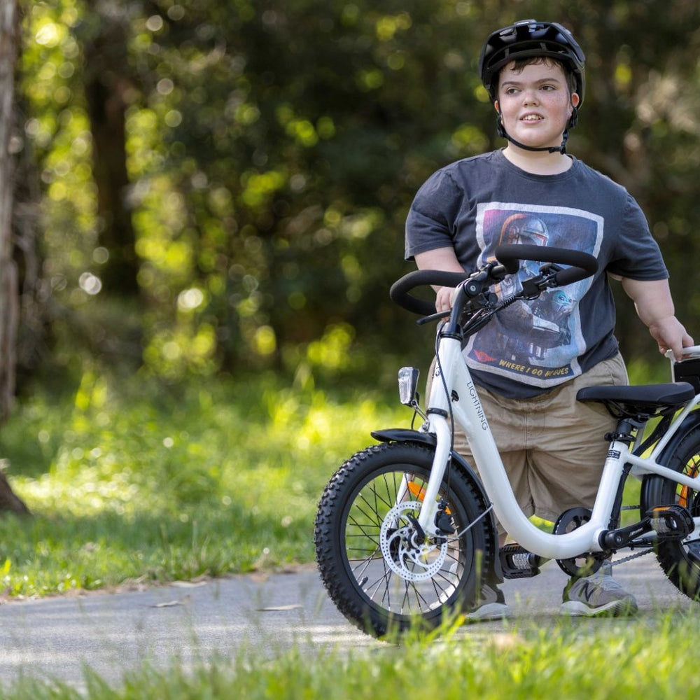 
                      
                        short stature rider next to white lightning bike
                      
                    