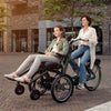 Women riding Huka Diaz Electric Wheelchair Tandem Trike with girl at the front