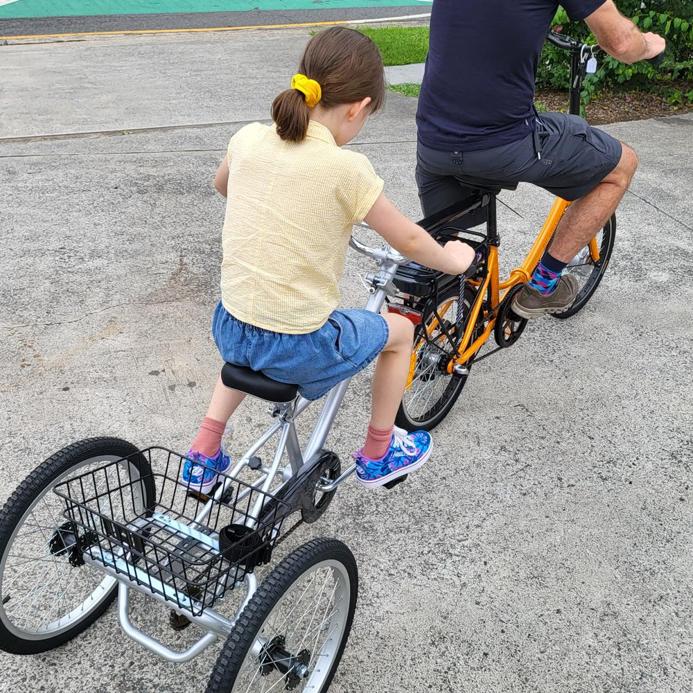 
                      
                        Young girl riding behind man on a Tandem Trailer Trike 
                      
                    