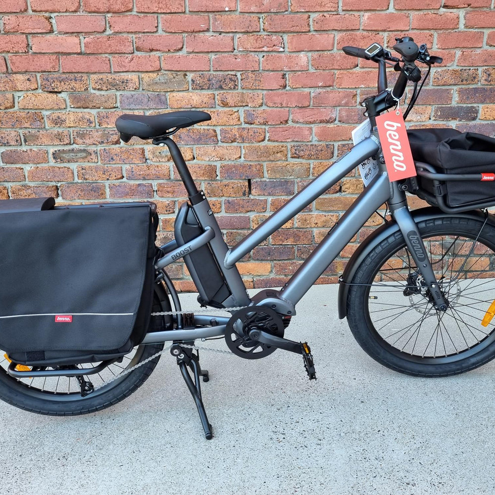 
                  
                    Silver Benno Boost electric long-tail cargo bike against brick wall
                  
                