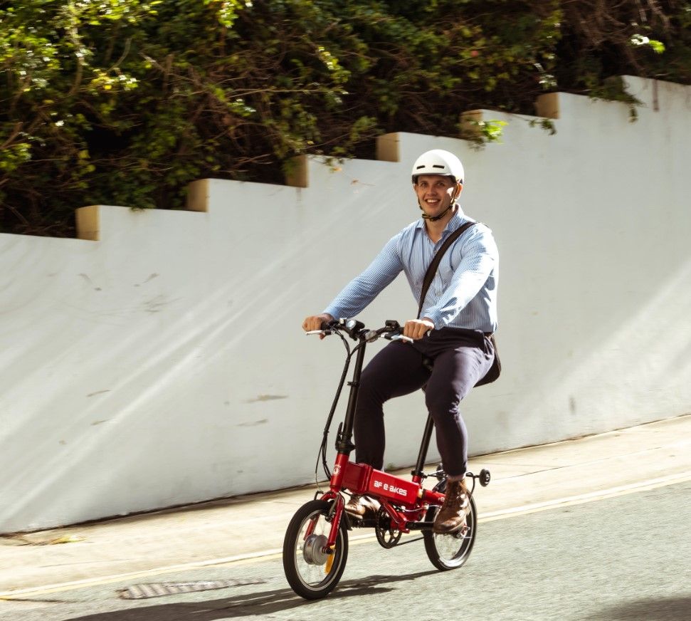 
                      
                        Man smiling while riding electric bike in the street
                      
                    