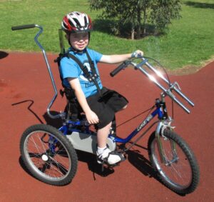 Happy kid riding special need tricycle
