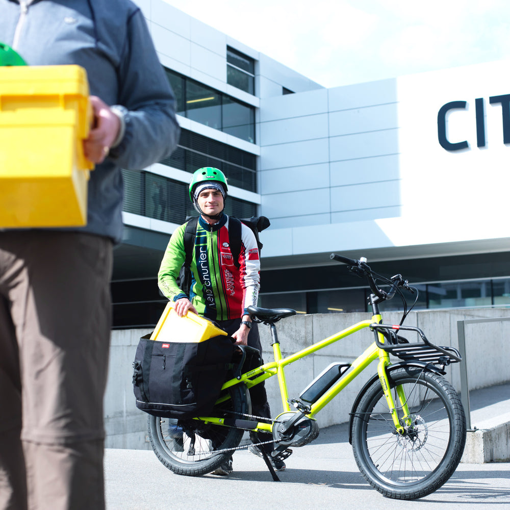 
                  
                    Mailman using Benno Boost electric long-tail cargo bike for deliveries
                  
                