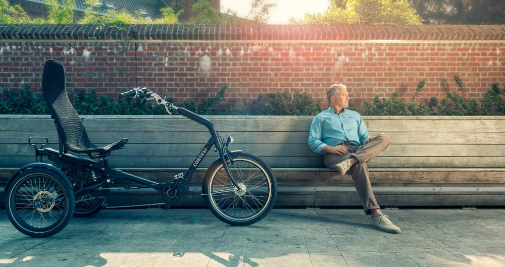 
                  
                    Man posing next to the Huka Cortes Electric Tricycle
                  
                