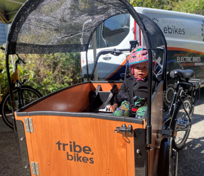 Kid sitting in ORIGINAL BOX CARGO BIKE - ELECTRIC PLUS MODEL