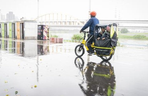 
                      
                        man riding Information on the Tern GSD S10 LX Electric Cargo ebike with kids in the rain
                      
                    